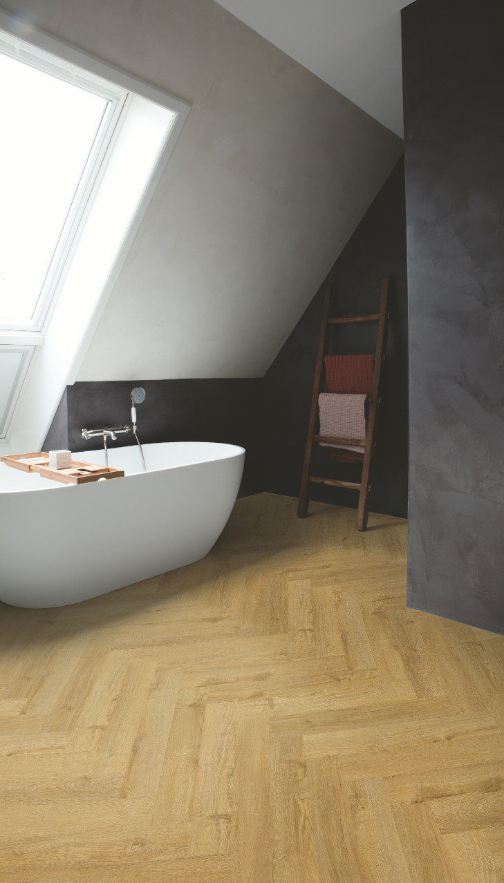 Fischgrät vinylboden quick-step fall oak natural verlegt auf dem Badezimmerboden.