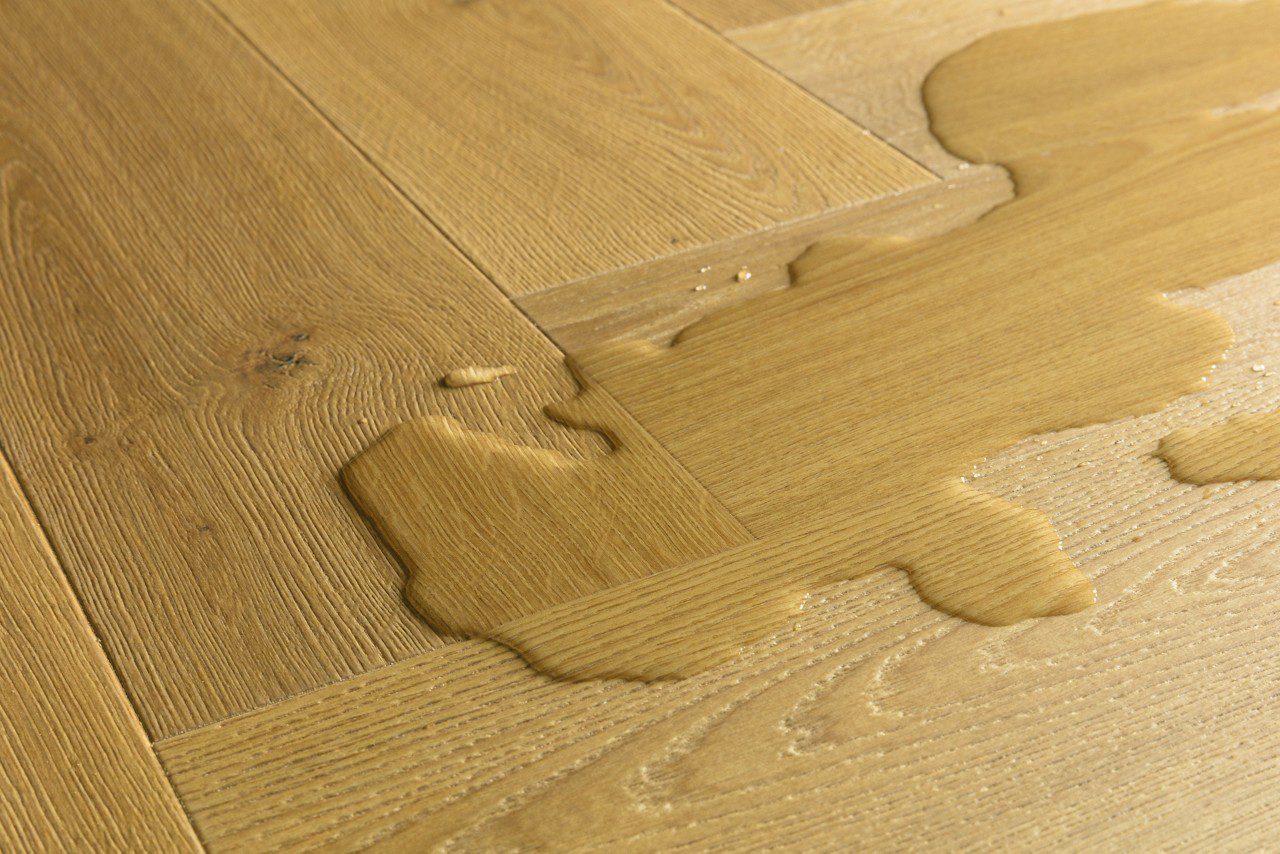 Laminaatparkett kalasaba Quick-Step Impressive Design Cumin Oak naturaalne toon ja sorteering. Veelomp laminaadil viitamaks selle veekindlusele.