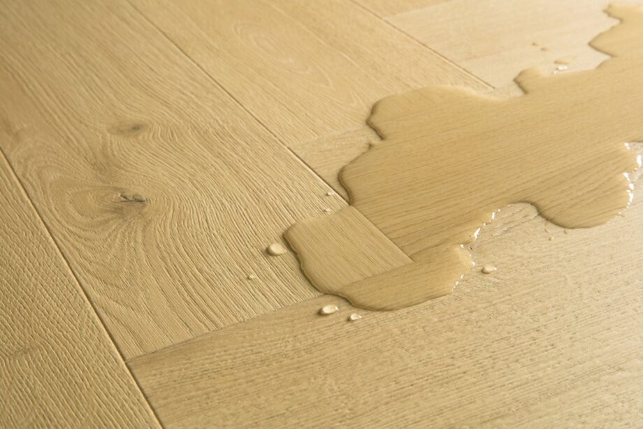 laminaatti-kalanruoto-quick-step-pergo-impressive-design-nutmeg-oak Laminaatti kalanruoto Quick Step Impressive Design Nutmeg Oak, lämmin keskiruskea tammen sävy ja tasainen lajitelma, vesilätäkkö osoittamassa vedenkestävyyttä