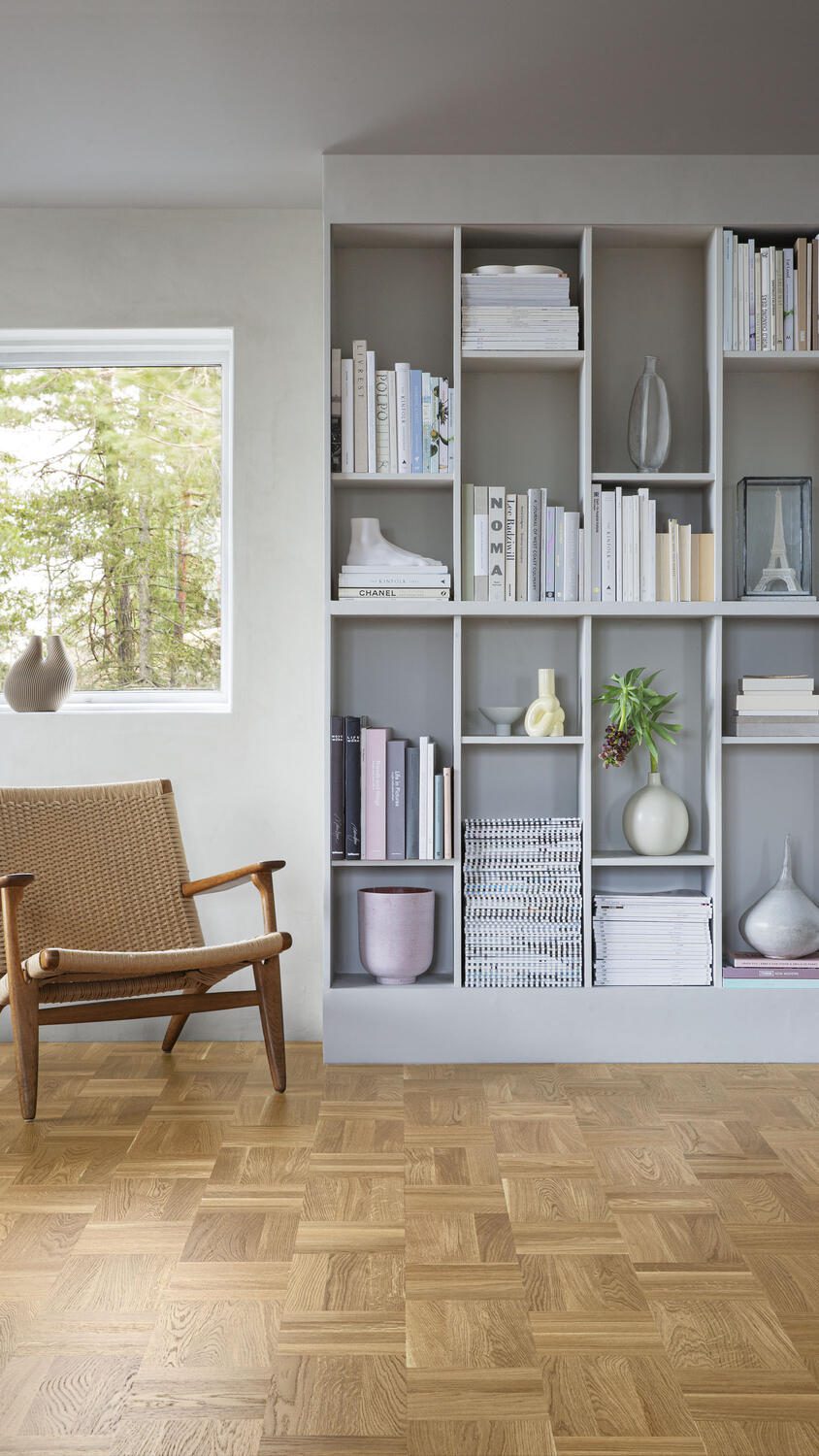 Ruutulauta Tarkett Noble Tammi Classic, luonnollinen, mattalakattu. Asennettu olohuoneen lattialle. Kirjahylly, tuoli ja ikkuna.