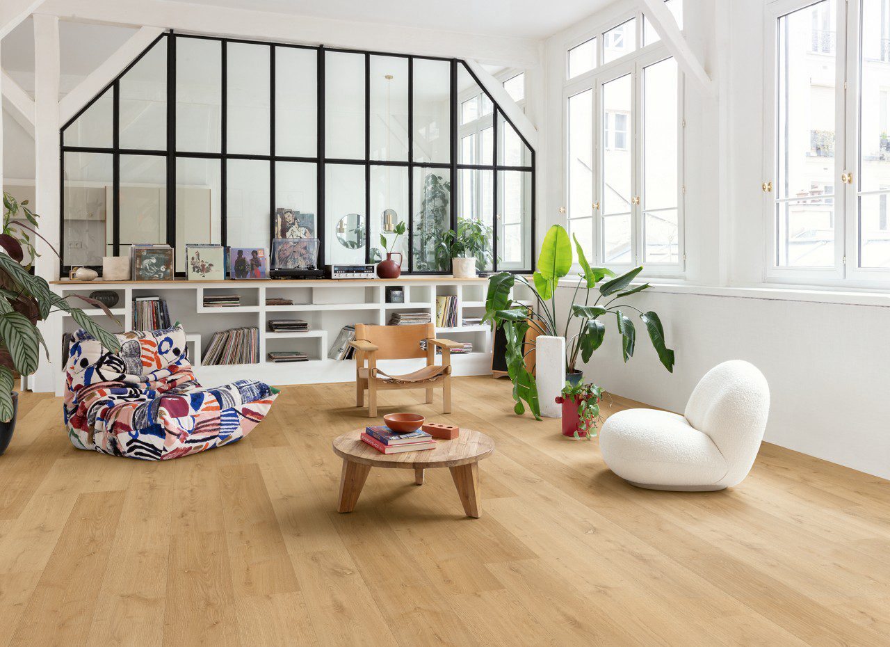 Klick Vinyl Quick Step Bloom Elegant Oak Natural im Wohnzimmer verlegt, Sessel, Tisch, Regal und Topfpflanzen.