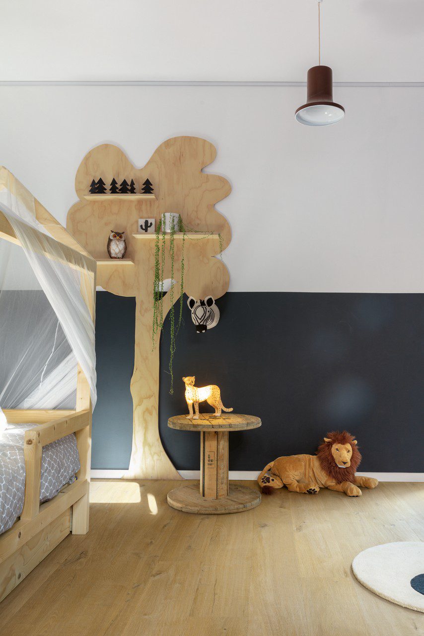 Klickvinyl Quick Step Bloom Cotton Oak Deep Natural im Kinderzimmer verlegt, Kinderbett mit Baldachin, wandmontiertes Holzregal in Baumform, weiches Löwen-Kuscheltier auf dem Boden.