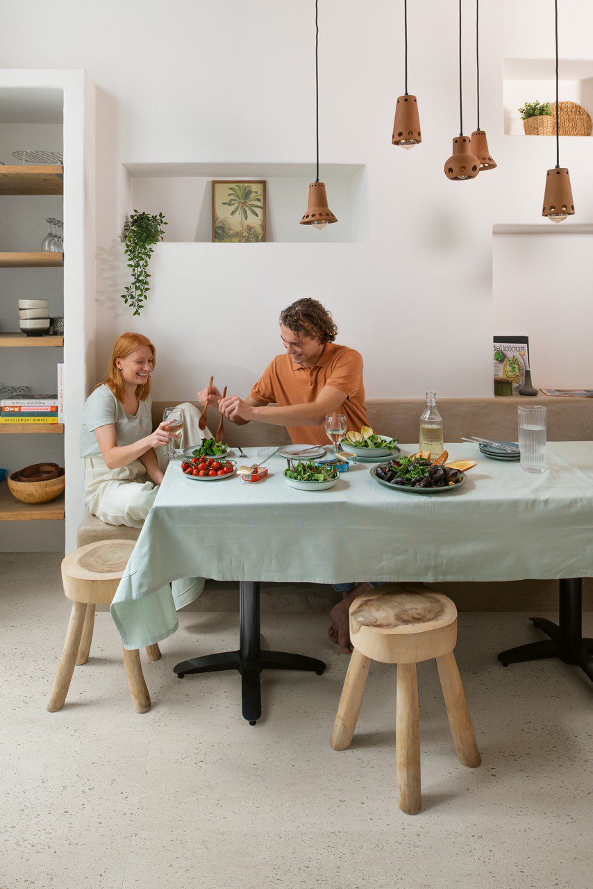lVT flooring Quick-Step Illume Oyster concrete installed on a kitchen floor. Man and a woman are having lunch.