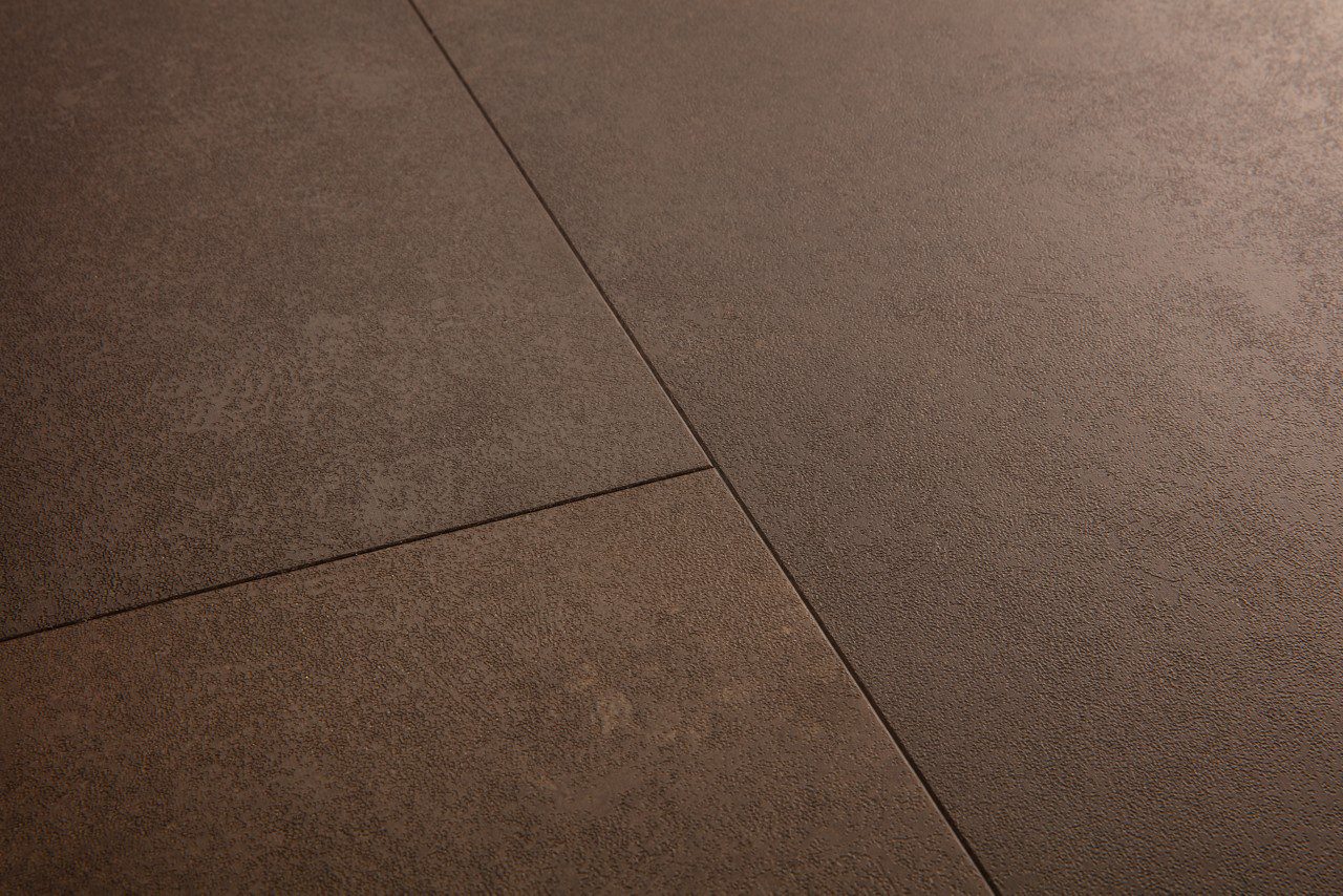Vinüülparkett Quick-Step Oro Cinnamon rock sooja pruuni tooni ja faasitud looduskivist põrandaplaadi disainiga.