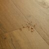 LVT parkett Quick-Step Bloom Botanic caramel oak tooni ja disaini kirjeldus. Veepiisad parketil viitamaks veekindlusele.
