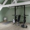 Quick Step Bloom Cotton Oak Cozy Grey vinyl flooring installed in a home gym, with strength training equipment.