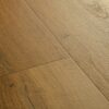 Vinyylilankku Quick Step Bloom Botanic Caramel Oak, lämmin karamellinruskea tammen sävy ja lankkudesign.