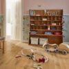 puitparkett–bauwerk-casapark-budget-cut-tamm-56-harjatud-olivaha Puitparkett Bauwerk Casapark Budget Cut Tamm 56 harjatud ja õlivahatatud pinnaga paigaldatud lasteto põrandale. Riiul raamatute ja mänguasjadega. Põrandale erinevad laiali mänguasjad.