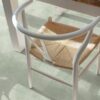 Vinylboden in Betonoptik Quick-Step Illume Soft Sage, verlegt auf dem Küchenboden – rustikaler Esstisch und Stuhl in Nahaufnahme; heller, sanfter Salbeigrün-Ton mit dezentem, steinartigem Design.