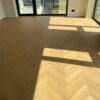 Bauwerk Monopark ek Natur 15 Avorio fiskbensparkett i ett rymligt rum Fiskbensparkett Bauwerk Monopark ek Natur 15 Avorio i ett rymligt ljust rum med stora fönster